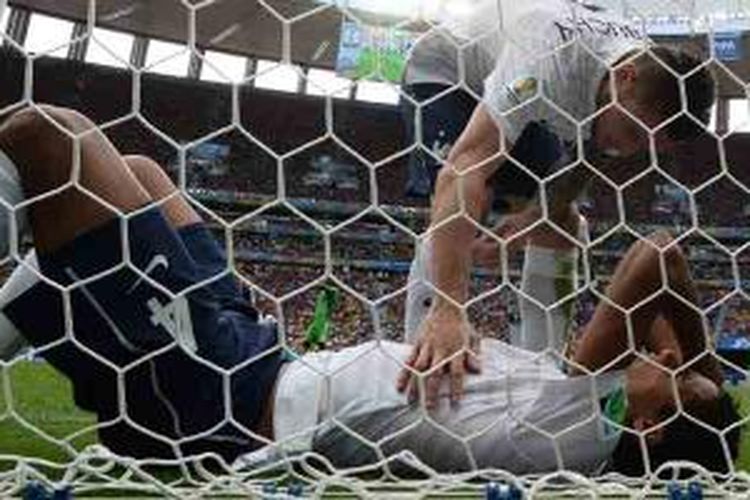 Bek Perancis, Mathieu Debuchy, mengecek kondisi rekan setimnya, Raphael Varane, yang terbaring, dalam laga perdelapan final Piala Dunia 2014 melawan Nigeria, Senin (30/6/2014) di Mane Garrincha National Stadium.