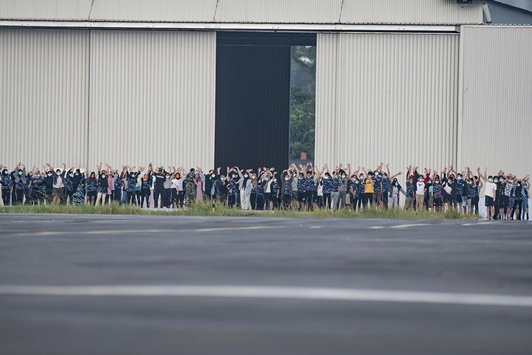 Sejumlah warga negara Indonesia (WNI) yang dievakuasi dari Wuhan, Hubei, China melambaikan tangan ke arah awak media saat akan melakukan senam bersama prajurit TNI pada hari ketigabelas di Hanggar Pangkalan Udara TNI AU Raden Sadjad, Ranai, Natuna, Kepulauan Riau, Jumat (14/2/2020). Menurut Sekretaris Direktorat Jenderal Pencegahan dan Pengendalian Penyakit dr Achmad Yurianto, sudah diputuskan bahwa observasi WNI dari Wuhan yang saat ini tinggal di Natuna, berakhir pada 15 Februari esok hari, pukul 12.00 WIB.