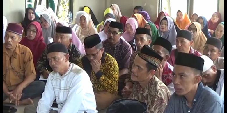 Kemenag Pasangkayu kumpulkan warga dan tokoh masyarakat untuk sosialisasi soal shalat berjamaah di rumah untuk hindari penyebaran Covid-19, Sabtu (11/4/2020). Ironisnya, para warga duduk berdekatan dan tidak mengenakan masker. Tampak Kepala Kemenang Pasangkayu Mustafa memberikan arahan ke warga,