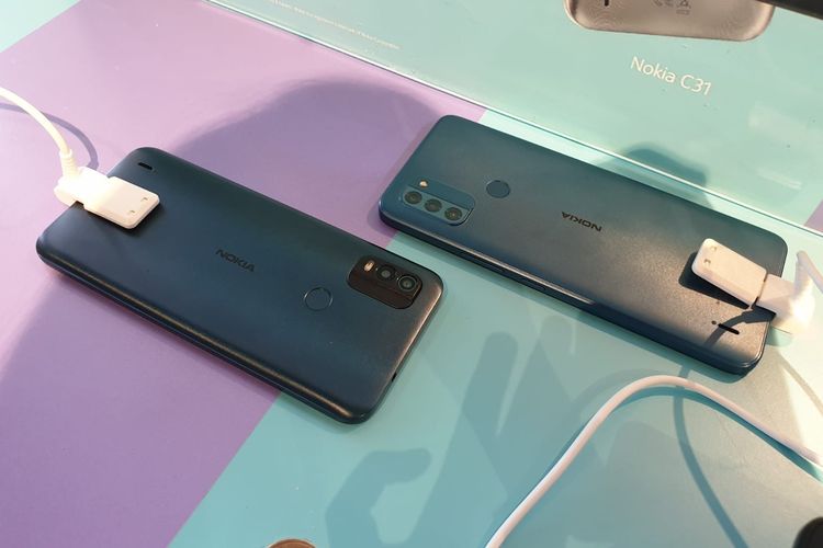 Bagian belakang Nokia C21 Plus (kiri) dan Nokia C31 (kanan). Perbedaan yang terlihat jelas adalah jumlah kamera. Nokia C21 Plus memiliki dua kamera belakang, sementara Nokia C31 membawa tiga kamera. 