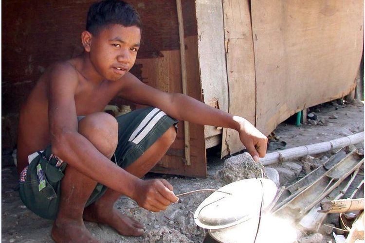 Seorang anak laki-laki pengungsi Timor Timur memanak nasi di kamp pengungsi Noelbaki di Kupang, NTT, 09 Mei 2002.