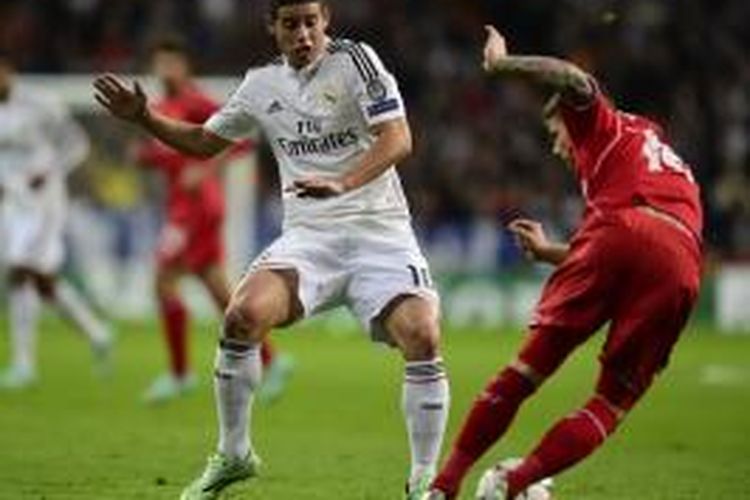 Gelandang Real Madrid, James Rodriguez, saat berupaya menghadang bola tendangan pemain Liverpool, Alberto Moreno, pada pertandingan keempat Grup B Liga Champions di Stadion Santiago Bernabeu, Selasa (4/11/2014). 