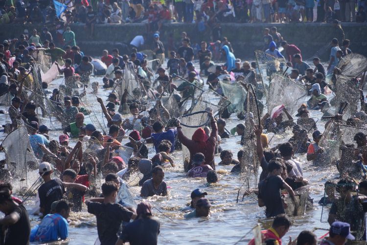 Warga berebut ikan dalam Festival Memet Ikan di Desa Gemblegan, Kecamatan Kalikotes, Klaten, Jawa Tengah, Minggu (20/7/2025).