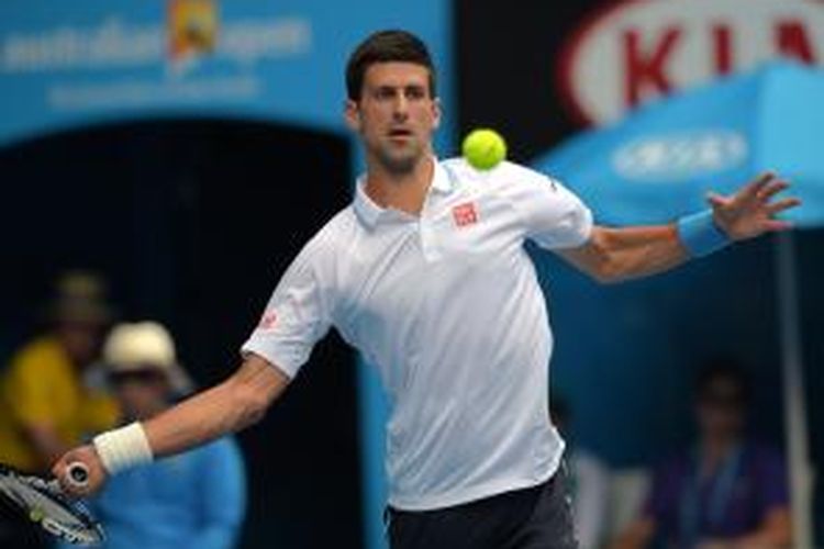 Petenis Serbia, Novak Djokovic, berusaha mengembalikan bola ke arah petenis Rusia, Andrey Kuznetsov, pada babak kedua Australia Terbuka di Melbourne Park, Kamis (22/1/2015). Djokovic menang 6-0, 6-1, 6-4.