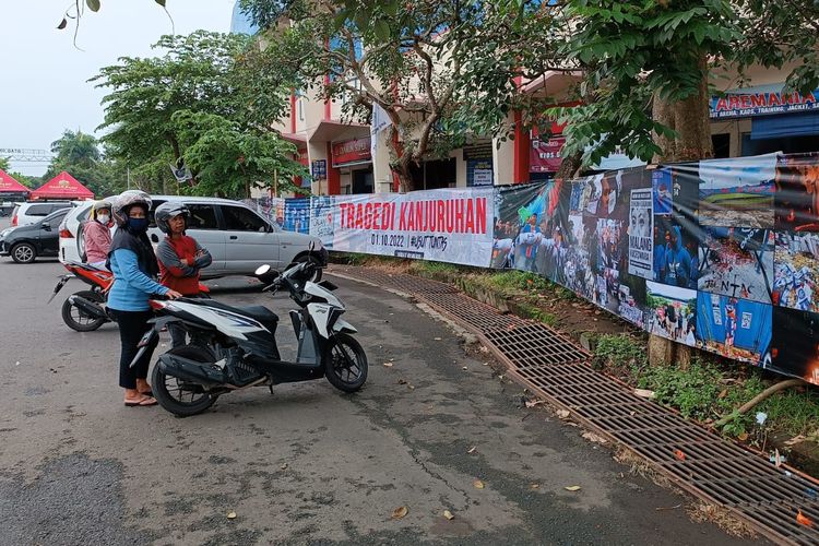 Salah satu warga saat melihat banner berisi foto karya jurnalistik Jurnalis Malang Raya di Stadion Kanjuruhan, Rabu (9/11/2022).