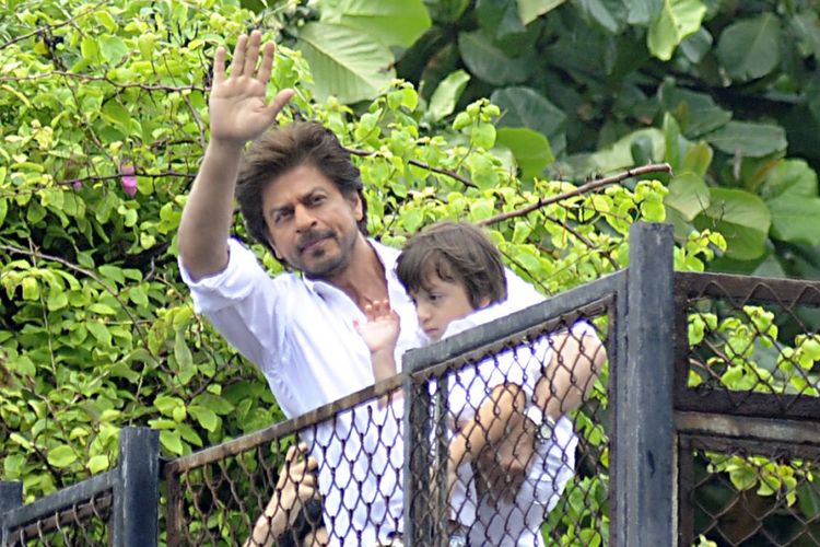Sambil menggendong putra bungsunya, aktor Bollywood Shah Rukh Khan menyapa para fans yang berkumpul di depan rumahnya di Mumbai, pada hari raya Idul Fitri, Senin (26/6/2017).