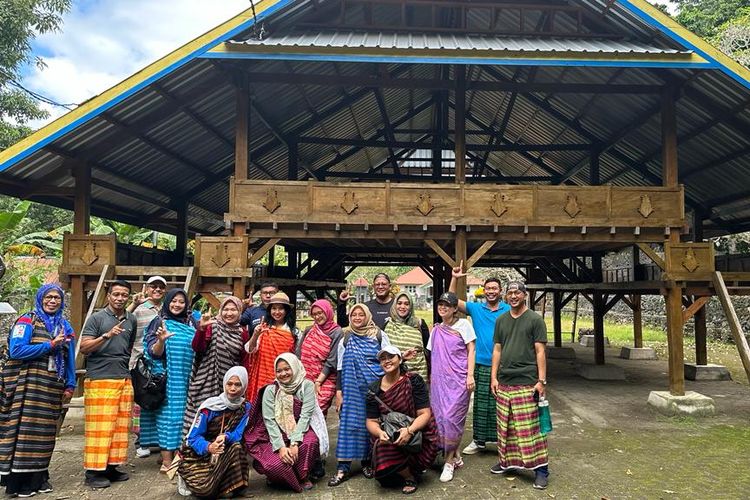 Pengunjung berfoto bersama beberapa warga Liya Togo di baruga yang ada di Desa Loya Togo, Wangi-wangi, Wakatobi, Sulawesi Tenggara.