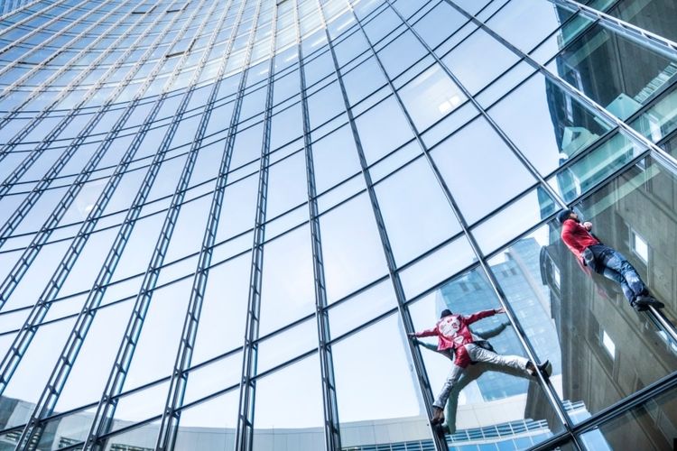 Alain Robert (kiri), yang dikenal sebagai Spiderman Perancis, dan Leo Urban memanjat gedung Menara SKYPER setinggi 153,8 meter di Frankfurt am Main, Jerman barat pada 23 November 2021. 