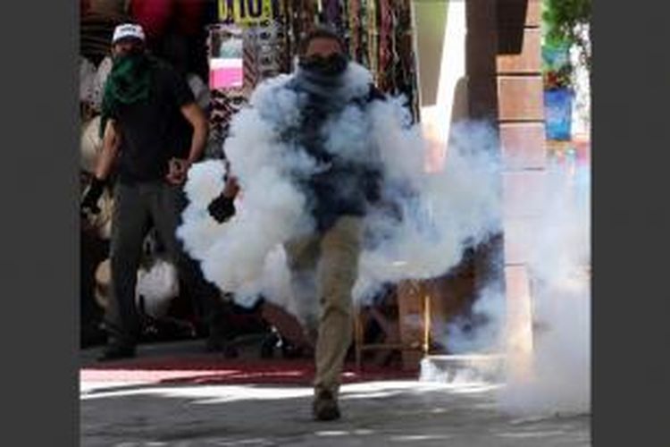 Demonstran bentrok dengan polisi selama protes terhadap Perdana Menteri Turki Tayyip Erdogan di Ankara, 1 Juni 2013. Polisi memblokir sekelompok demonstran yang berbaris menuju parlemen dan kantor perdana menteri.