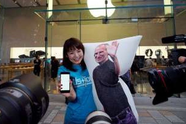 Seorang fanboy di Jepang mengantre iPhone 7 bersama bantal Steve Jobs. 