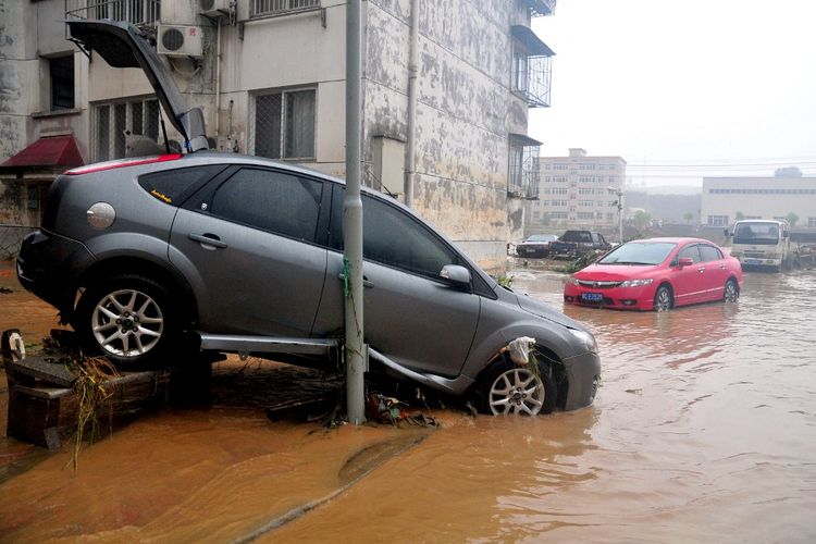 Foto yang diambil pada tanggal 6 Agustus 2012 ini menunjukkan mobil-mobil yang rusak di pinggir jalan setelah badai Topan Saola menghantam Shiyan, di provinsi Hubei, China tengah, dan menewaskan 14 orang. Filipina kali ini dihantam topan serupa.