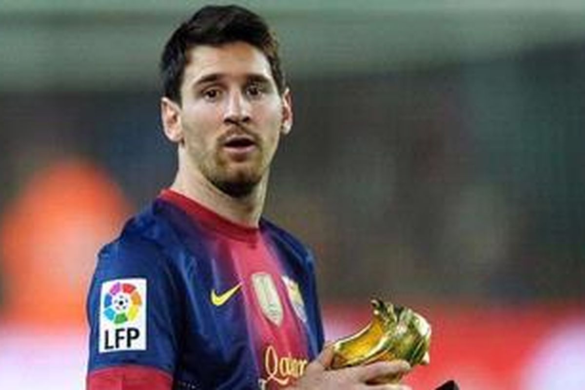 Penyerang Barcelona, Lionel Messi, mempresentasikan Sepatu Emas yang baru diraihnya pada pertandingan  Liga BBVA melawan Celta Vigo, di Camp Nou, Sabtu (3/11/2012). 