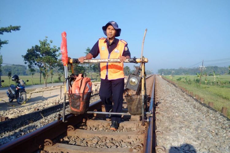 Penilik jalur kereta api PT KAI Daop Tujuh Madiun, Madyani berjalan memeriksa keamanan rel kereta api, Kamis (25/5/2017) pagi.