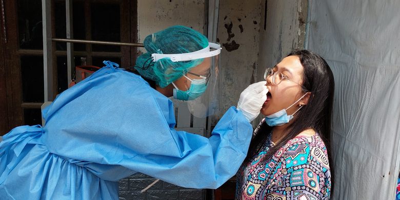 Wahyu (28), seorang dokter dari Puskesmas Kecamatan Tamansari melakukan pemeriksaan warga di wilayah karantina mikro di RW 02, Kelurahan Krukut, Kecamatan Tamansari, Jakarta Barat, Jumat (14/1/2022).