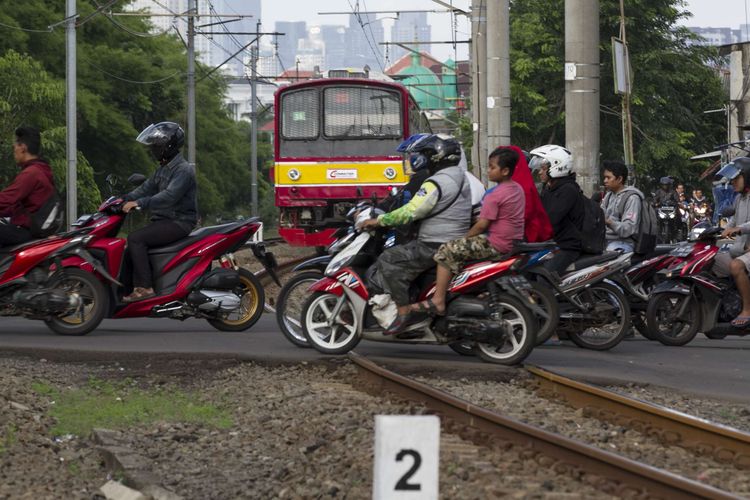 Pengguna jalan melintas di perlintasan kereta api wilayah Bumi Bintaro Permai, Pondok Aren, Jakarta Selatan, Minggu (23/2/2020). Tidak berfungsinya palang pintu di perlintasan kereta api sejak 2 tahun lalu mengancam keselamatan warga.