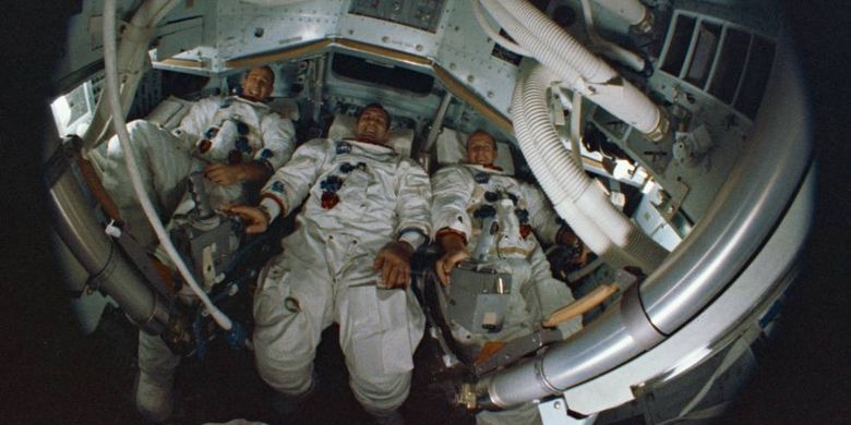 Tiga orang astronot Apollo 12, Bean, Gordon, dan Conrad terlihat melalui lensa mata-ikan di dalam Command Module simulator.