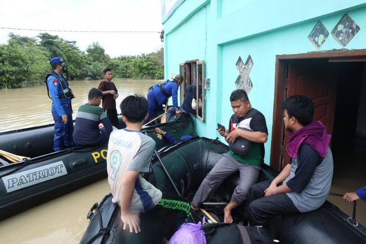 Tim Ditpolairud Polda Riau mendatangi warga yang terjebak Banjir untuk di evakuasi menggunakan perahu karet. 