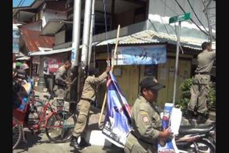 Puluhan satuan polisi pamong praja (Satpol-PP) Pemerintah Kota Ambon menertibkan atribut kampanye partai politik dan baliho para caleg di sejumlah kawasan yang terlarang di Kota Ambon, Senin (24/3/2014). 