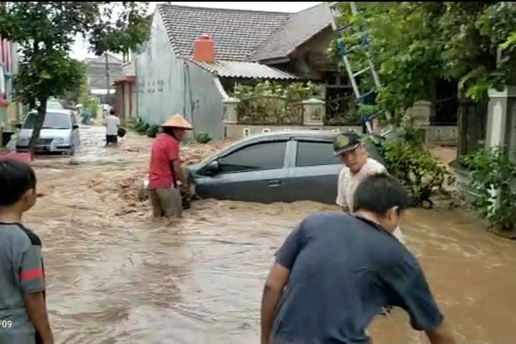 Warga Jember mengavakuasi mobil yang terdampak banjir pada Minggu (9/1/2022)