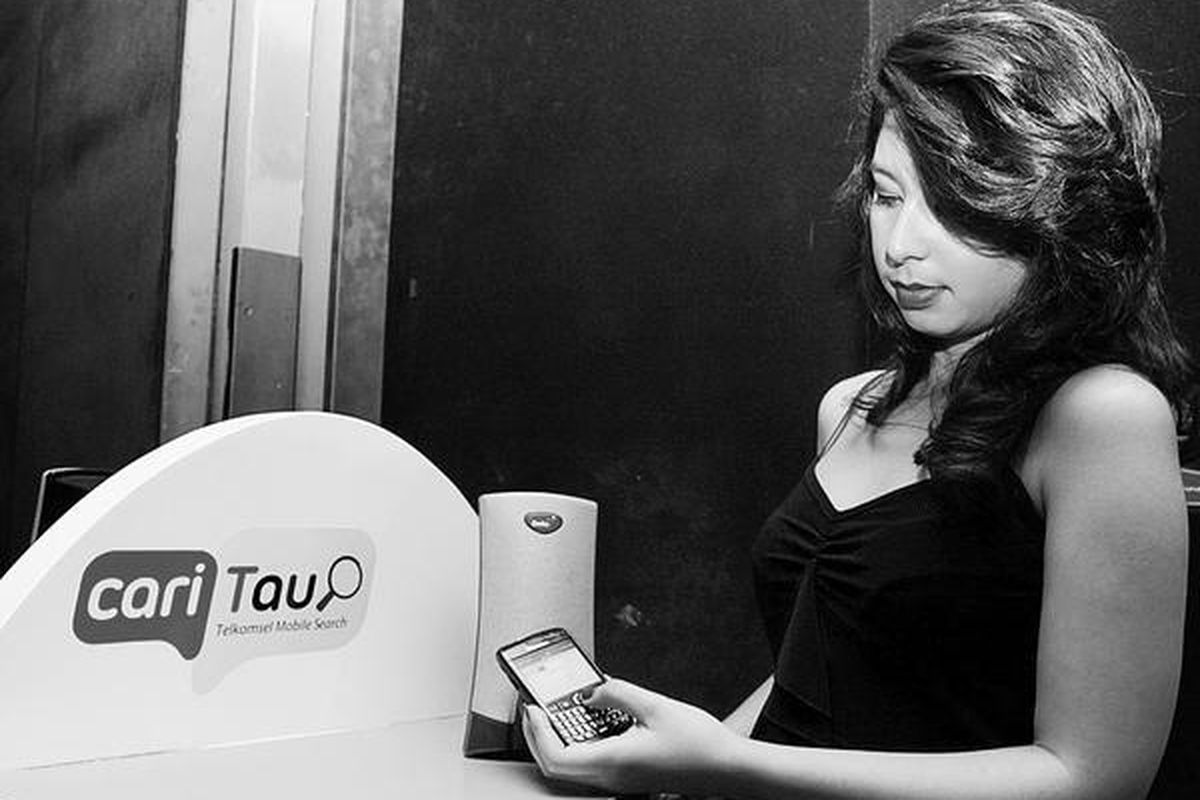 Pelanggan Telkomsel sedang menggunakan ponselnya untuk mendeteksi lagu yang sedang didengarkan dengan layanan Cari Tau. Pelanggan bisa mengetahui jutaan judul lagu dalam negeri dan mancanegara beserta artis yang membawakan sekaligus mengunduh nada sambung pribadi (NSP), mini song, full track dengan menghubungi 9090.