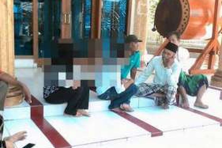 Kedua remaja yang diduga berbuat mesum, saat diinterogasi warga di pelataran masjid.