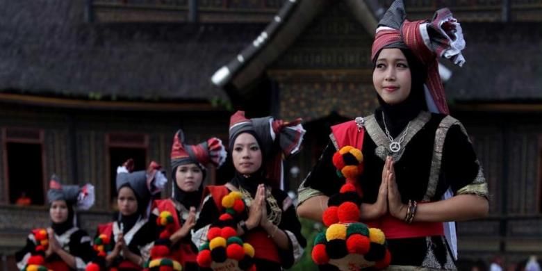 Perempuan menggunakan pakaian adat Sumatera Barat saat penyambutan tamu di garis finish etape tiga Tour de Singkarak 2013 di Istano Basa Pagaruyung, Nagari Pagaruyung, Kabupaten Tanah Datar, Sumatera Barat, Selasa (4/6/2013).