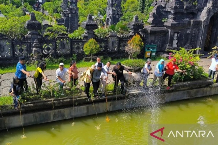 Anggota Dewan Perwakilan Daerah Made Mangku Pastika bersama perwakilan komunitas peduli lingkungan Bali Tresna Sujati saat menuangkan eco enzyme di kolam Monumen Perjuangan Rakyat Bali Denpasar, Selasa (6/2/2024).