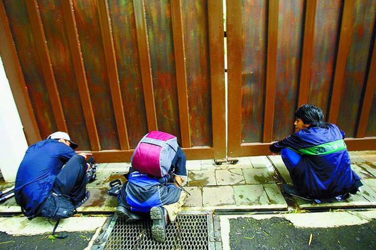 Wartawan mencoba mengambil gambar rumah Sjamsul Nursalim di Jalan Terusan Hang Lekir II Nomor WG 9, Jakarta Selatan, Senin kemarin. Jaksa Urip Tri Gunawan ditangkap petugas Komisi Pemberantasan Korupsi di rumah tersebut, Minggu (2/3) petang.  