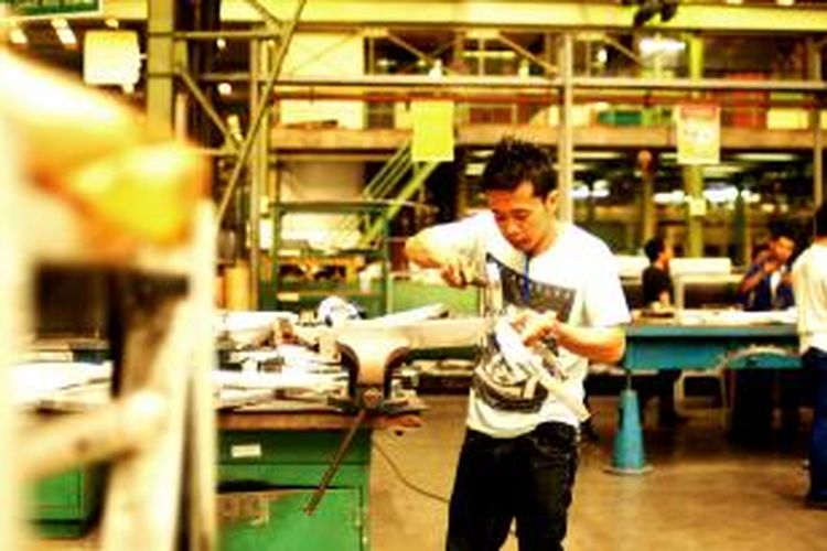 Karyawan PTDI membentuk lempeng metal menjadi komponen pesawat terbang di metal forming shop, PT Dirgantara Indonesia, Bandung, Jumat (14/2/2014).