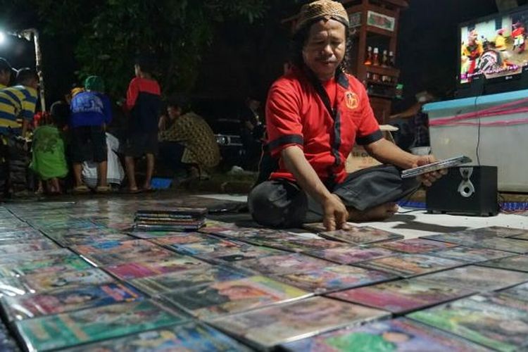 Narsum, seorang penjual DVD pertunjukkan wayang kulit, menggelar barang dagangannya saat HUT PDI-P di Lenteng Agung, Jakarta Selatan, Sabtu (28/1/2017).