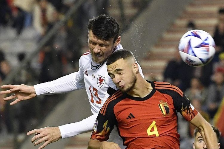 Penyerang Wales Kieffer Moore (kiri) menyundul bola selama pertandingan sepak bola Nations League A Grup 4 antara Belgia dan Wales di Stadion King Baudouin di Brussels pada 22 September 2022. (Photo by John THYS / AFP)