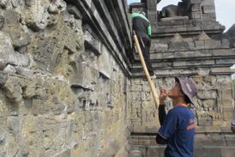 Petugas membersihkan dinding Candi Borobudur, Kabupaten Magelang, Jawa Tengah, Rabu (10/6/2015).