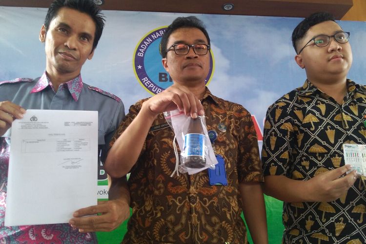 Kepala BNNK Banyumas Agus Untoro (tengah) menunjukkan minuman kunyit dalam botol minuman berenergi saat konferensi pers di Kantor BNNK Banyumas, Jawa Tengah, Jumat (27/12/2019).