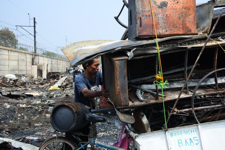 Seorang pria hendak membawa hasil kumpulan sisa-sisa besi dan logam dari lokasi kebakaran permukiman di RT 10 RW 01, Kelurahan Semenan, Kecamatan Kalideres, Jakarta Barat, Kamis (29/8/2019).