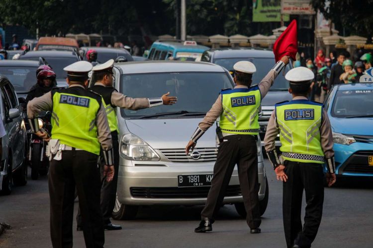 Sejumlah petugas kepolisian memberi arahan kepada pengendara mobil pada uji coba ganjil genap di ruas Tol Jagorawi, Jakarta, Senin (16/4/2018). Uji coba yang dilakukan setiap hari Senin-Jumat kecuali hari libur nasional tersebut dimulai pukul 06.00 hingga 09.00 WIB diharapkan dapat mengurai kemacetan.