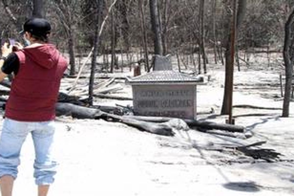 Seorang turis mengabadikan daerah yang tersapu awan panas Merapi atau yang biasa disebut wedhus gembel oleh masyarakat setempat.