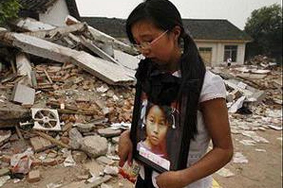 Seorang ibu mendekap foto anaknya yang hilang.