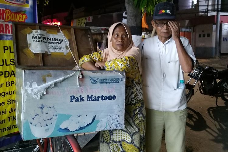 Sriyati menemani Martono (68) suaminya yang menderita glukomo berjualan makanan ringan di depan Indomaret Jalan Cokroaminoto, Kota Madiun untuk mencukup kebutuhannya sehari-hari.