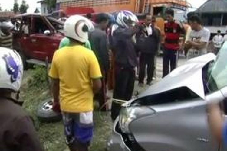 Warga berkerumun melihat mobil rombongan pengantar pengantin yang bertabrakan dengan mobil peziarah di Desa Botto, Kecamatan Campalagian, Polewali Mandar, Sulawesi Barat, Minggu (14/12/2014). Empat penumpang termasuk seorang balita tewas dalam kejadian itu.
