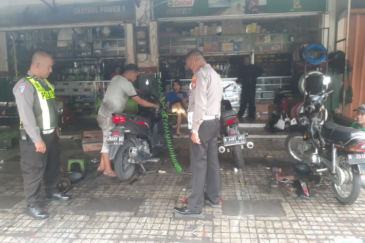 Petugas Satlantas Polresta Malang Kota mendatangi bengkel sepeda motor yang berada di sekitar simpang empat Institut Teknologi Nasional (ITN) Malang pada Selasa (16/1/2024).
