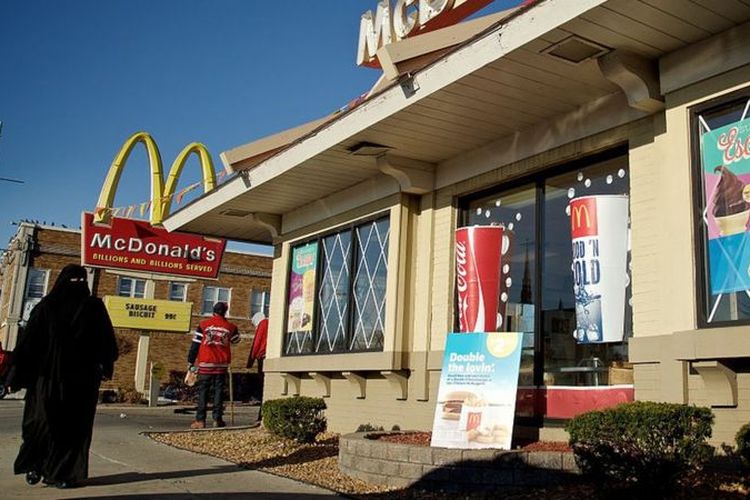 Seorang perempuan berjalan melewati McDonald's di Kota Hamtramck, Michigan, AS.