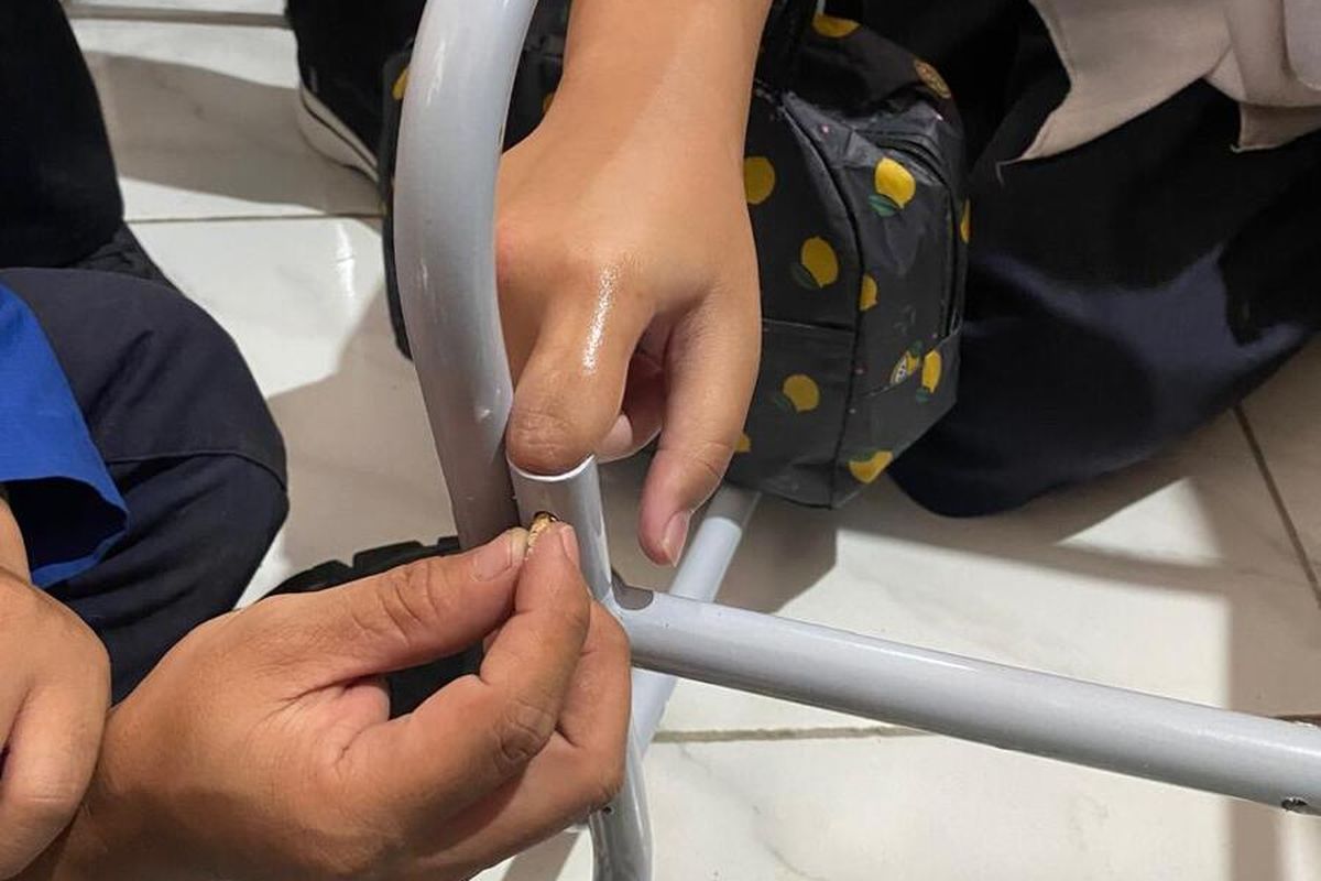 Petugas Diskar PB tengah berupaya mengeluarkan jari siswi yang masuk kedalam lubang kursi, Rabu(15/1/2025)