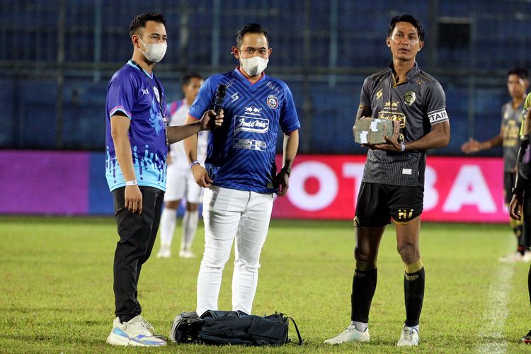 Chairman RANS Cilegon FC Raffi Ahmad (kiri) dan Presiden klub Arema FC Gilang Widya Pramana (tengah) menyerahkan hadiah uang sebesar 200 juta kepada Kapten Arema FC Johan Ahmad Farizi seusai uji coba yang berakhir dengan skor 6-2 di Stadion Kanjuruhan Kabupaten Malang, Jawa Timur, Minggu (6/6/2021) malam.