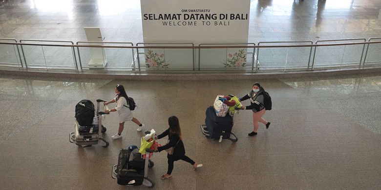 Penumpang pesawat membawa barang bawaannya di Terminal Kedatangan Internasional Bandara Internasional I Gusti Ngurah Rai Bali, Jumat (20/3/2020). Sebanyak 181.053 orang penumpang rute internasional tercatat tiba di bandara tersebut pada periode 1-19 Maret 2020, atau mengalami penurunan 40,2 persen jika dibandingkan catatan periode yang sama pada tahun 2019 yaitu sebesar 302.914 orang penumpang.