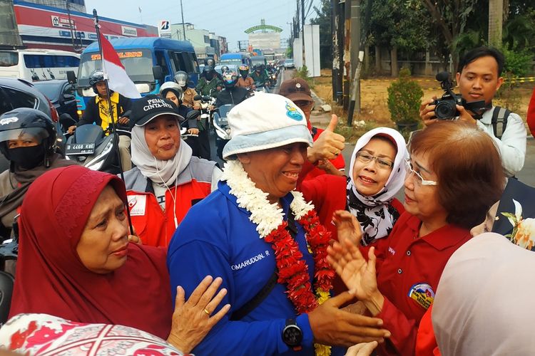 Komaruddin Hidayat (biru) terharu ketika ia disambut beelasan kawannya di perbatasan Kota dan Kabupaten Bekasi, Senin (28/10/2019) sore, usai 4 hari berjalan kaki dari Bandung menuju Jakarta. Komaruddin merupakan penyintas stroke.