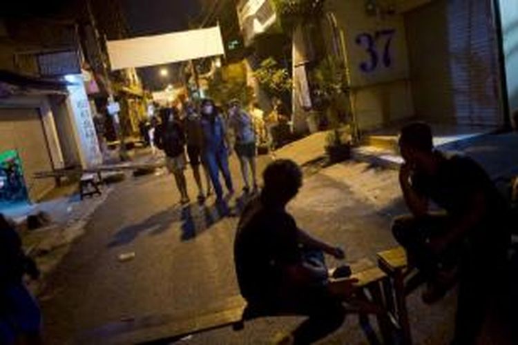 Para pekerja seks berjalan di kawasan Dolly, Surabaya, yang sepi, Rabu (18/6/2014) malam, setelah pemerintah kota resmi menutup kawasan prostitusi terbesar di Asia Tenggara tersebut.