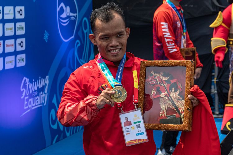 Perenang Indonesia Aris Wibawa menunjukkan medali emas usai meraih posisi pertama pada final renang gaya dada 100 meter putra kategori SB7 ASEAN Para Games 2022 di Stadion Jatidiri Semarang, Jawa Tengah, Senin (1/8/2022). Aris berhasil menyabet medali emas pertama para-renang untuk Indonesia dengan catatan waktu 1 menit 34,46 detik, sementara perak diraih perenang Kamboja Khouy Koy dengan catatan waktu 1 menit 39,54 detik dan perunggu oleh perenang Vietnam Ho Van Dao dengan catatan waktu 1 menit 47,36 detik. ANTARA FOTO/Aji Styawan/tom. *** Local Caption *** 1 menit 34,46 detik