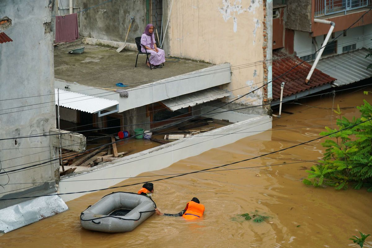 Warga bertahan di lantai 2 rumah karena terjebak banjir di Kampung Cililitan Kecil, Cililitan, Jakarta Timur, Selasa (4/3/2025). Banjir disebabkan oleh meluapnya air Sungai Ciliwung setelah pada malam sebelumnya kawasan Jabodetabek diguyur hujan lebat.