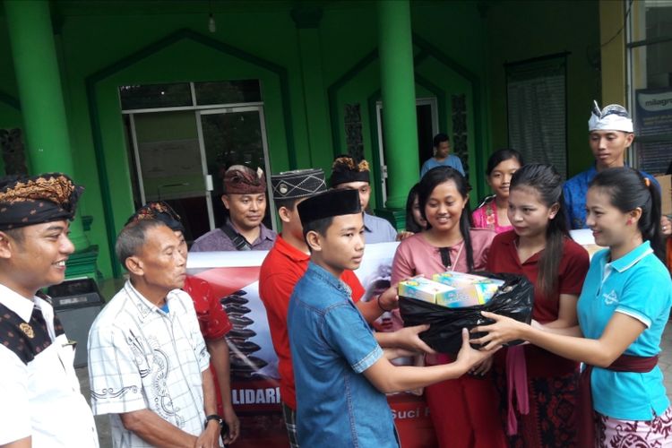 Para pemuda pemudi Hindu di Kendari membagi takjil kepada pengurus remaja Masjid Al Muhajirin Kendari (KOMPAS, com/KIKI ANDI PATI)