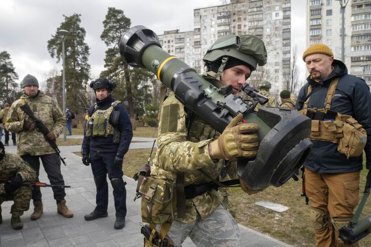 Seorang anggota Pasukan Pertahanan Teritorial Ukraina memegang senjata anti-tank NLAW, di pinggiran Kyiv, Ukraina, Rabu, 9 Maret 2022. Pihak berwenang mengumumkan gencatan senjata baru pada hari Rabu untuk memungkinkan warga sipil melarikan diri dari kota-kota di sekitar ibu kota, Kyiv, saat serta kota-kota selatan Mariupol, Enerhodar dan Volnovakha, Izyum di timur dan Sumy di timur laut. Upaya sebelumnya untuk membangun koridor evakuasi yang aman sebagian besar gagal karena serangan oleh pasukan Rusia.